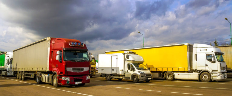 Colorful Modern Big Semi-trucks And Trailers Of Different Makes And Models Stand In Row On Flat Park