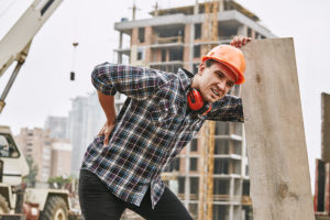 Hard Work. Construction Worker In Protective Helmet Feeling Back