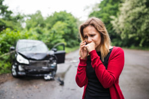 A Young Woman With Smartphone By The Damaged Car After A Car Acc